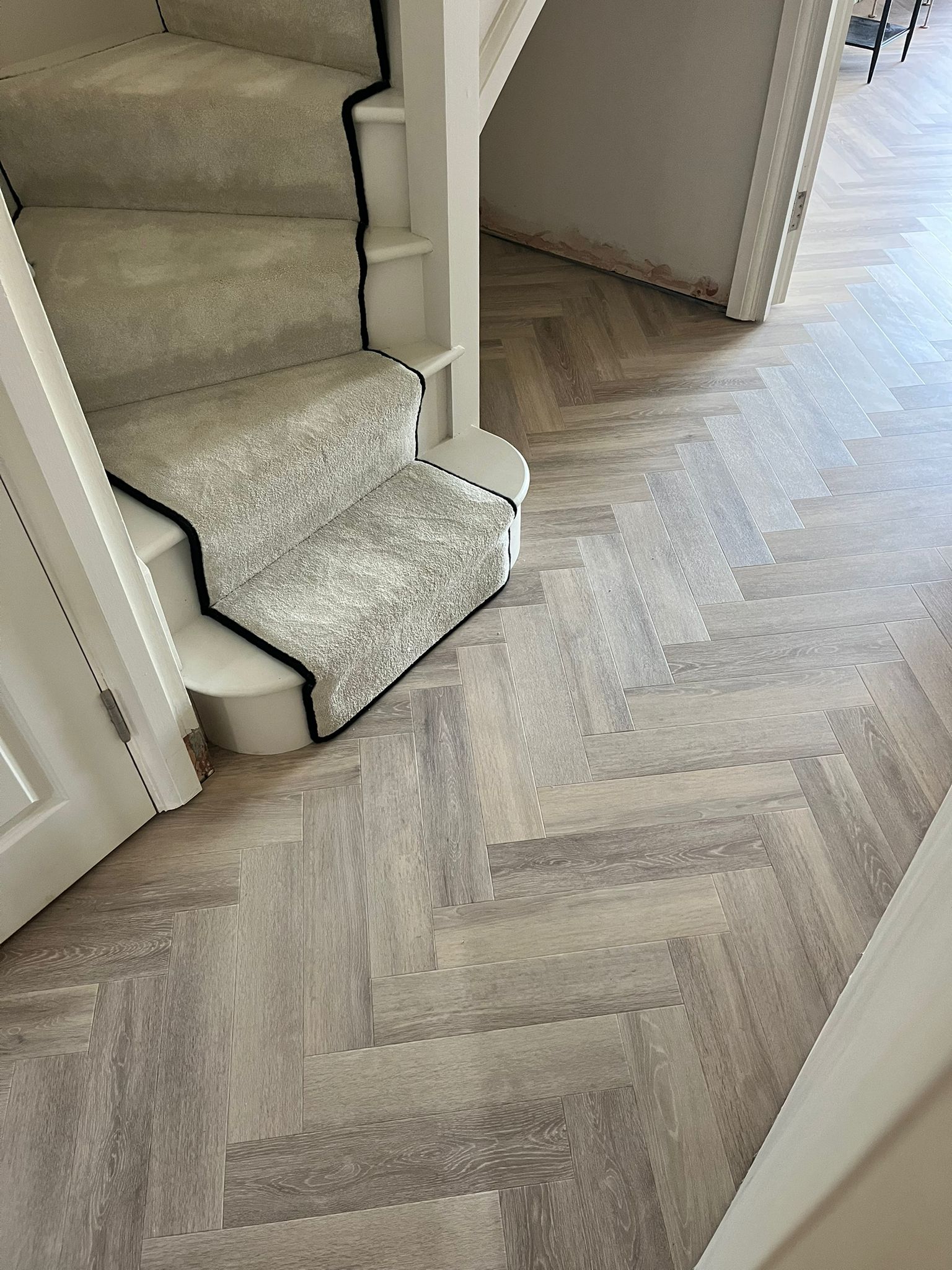 Amtico Spacia Herringbone LVT, laid to a lounge, dining room, hall and WC.